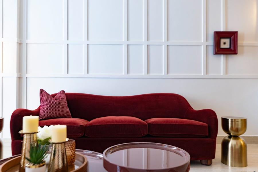 Burgundy velvet sofa against panelled wall