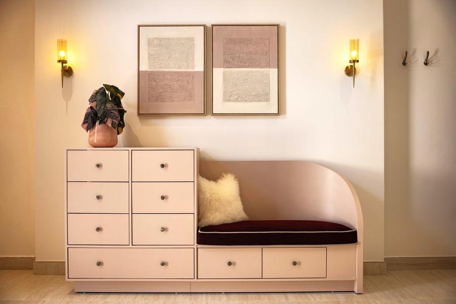 Pink dresser with tassel seat and abstract art